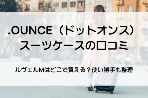 外国人女性が外国の街並みをスーツケースを弾きながら歩いている。
